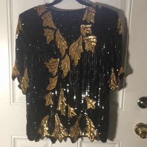 Black & gold sequined short sleeved top. Has rounded neck v in back size Large